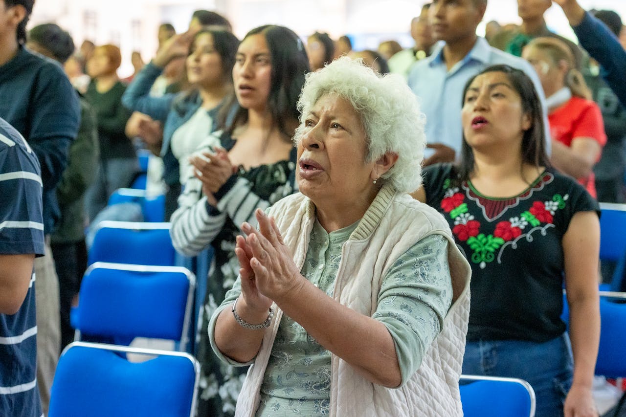 A diverse group of worshippers in Ciudad de México express their faith in a church gathering.