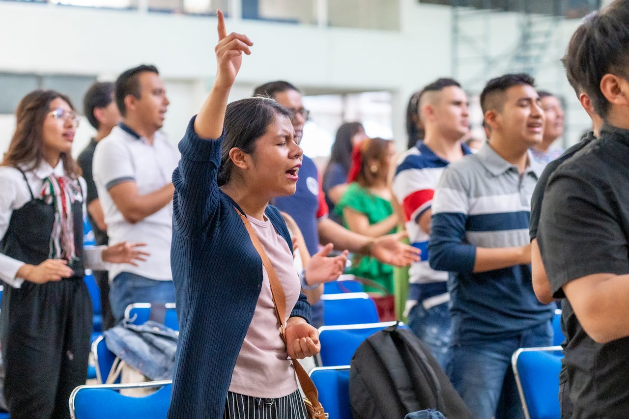 Diverse group of people passionately participating in a Christian worship session in Mexico City.