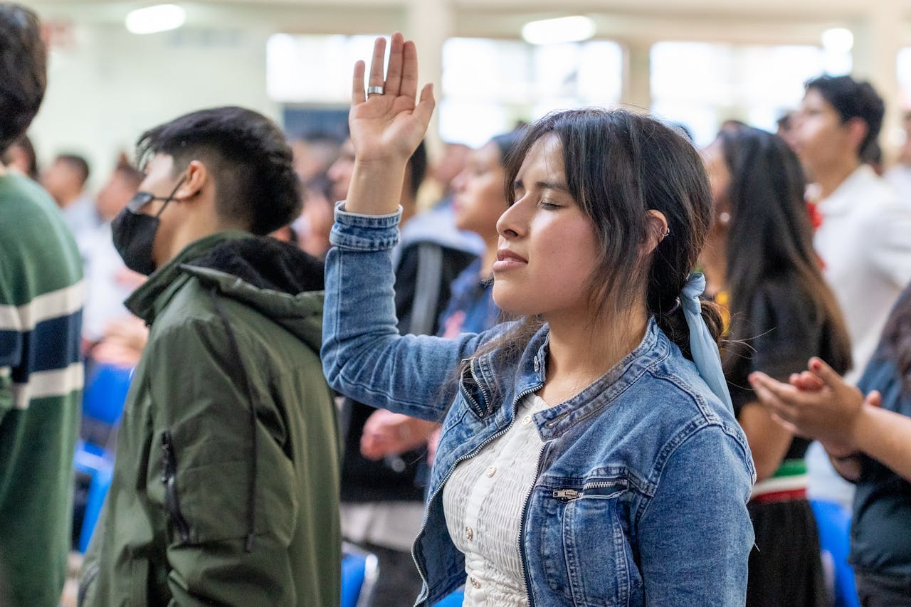 A diverse group of people engaged in worship, expressing adoration and community in Mexico City.